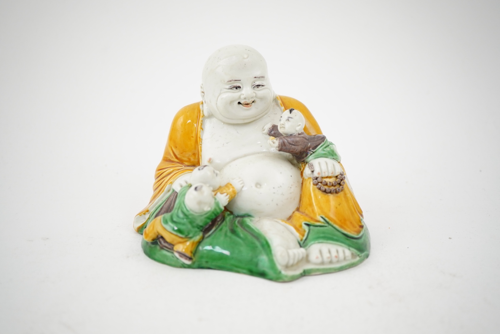 A Chinese sancai glazed biscuit group of Budai and three boys, 19th century